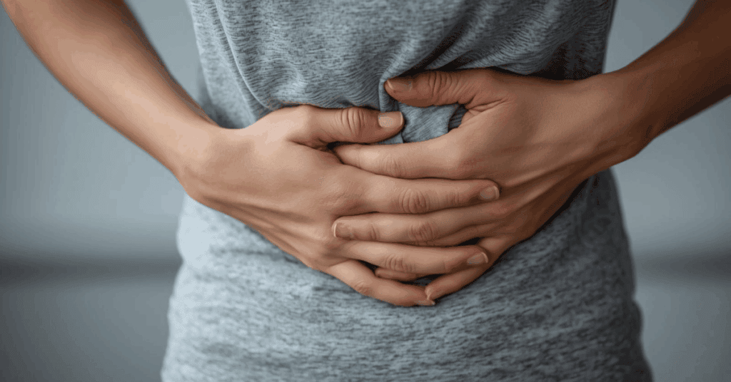 An image of a person clutching at their stomach with their hands 